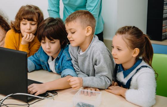 Lapsia katselemassa yhdessä tietokoneen ruutua.