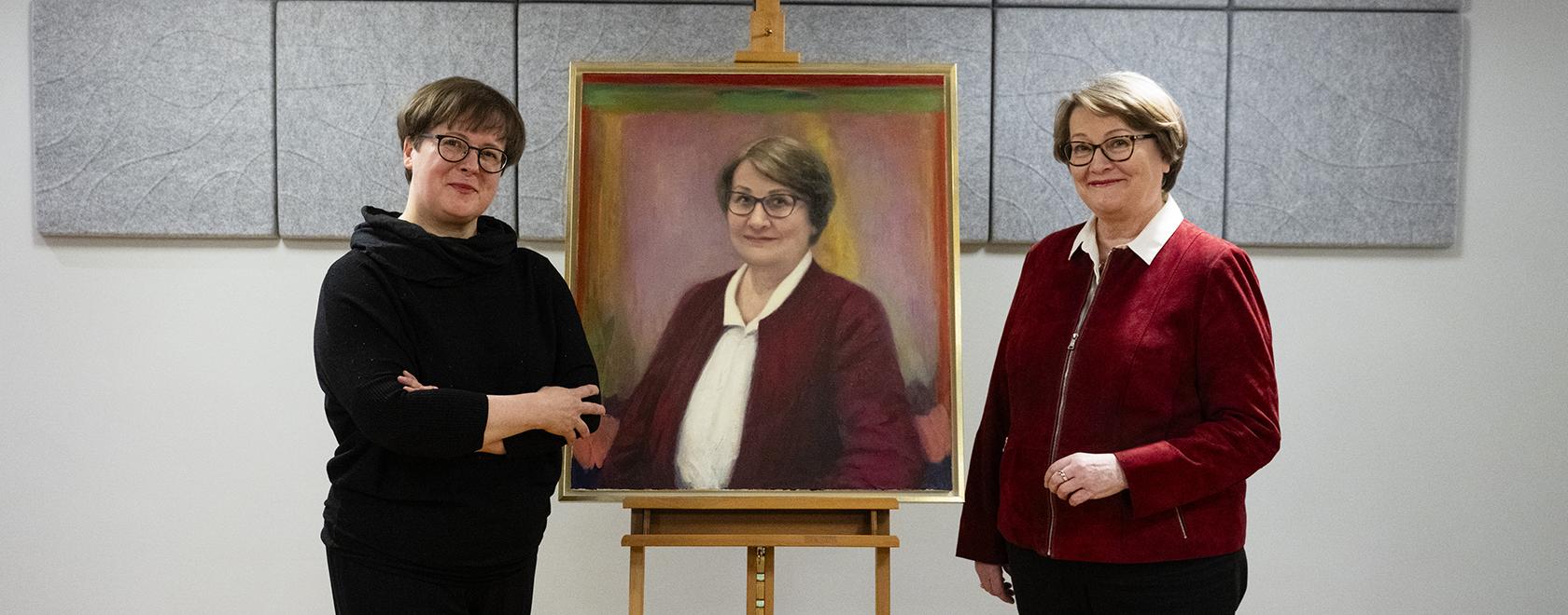 Kaksi naista seisoo oikealla olevaa naista esittävän muotokuvan molemmin puolin.